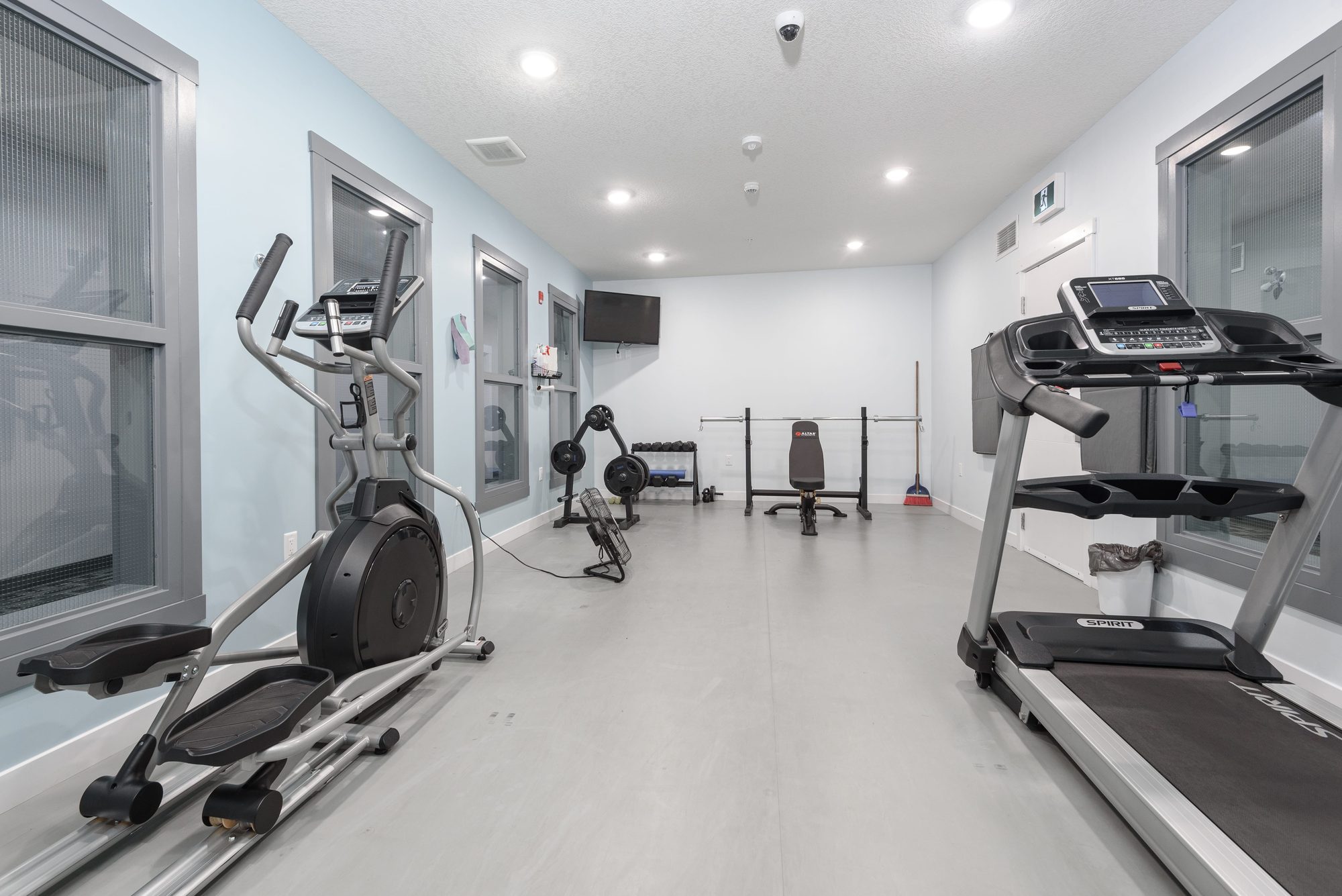 Fitness room with treadmill, elliptical, and weight bench at The Metro 1827