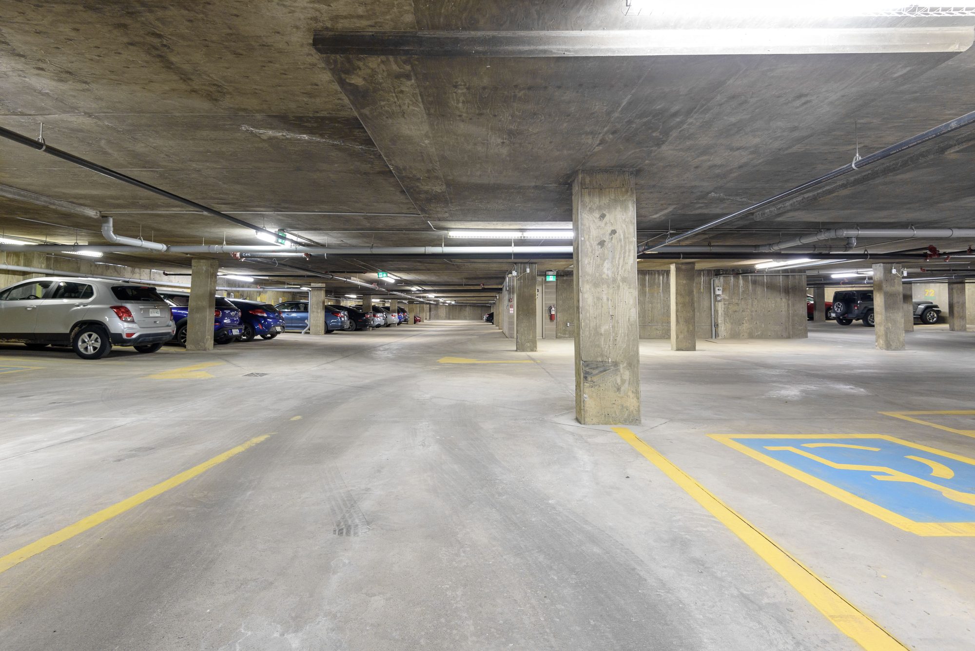Heated underground parkade with marked stalls beneath The Metro 1827