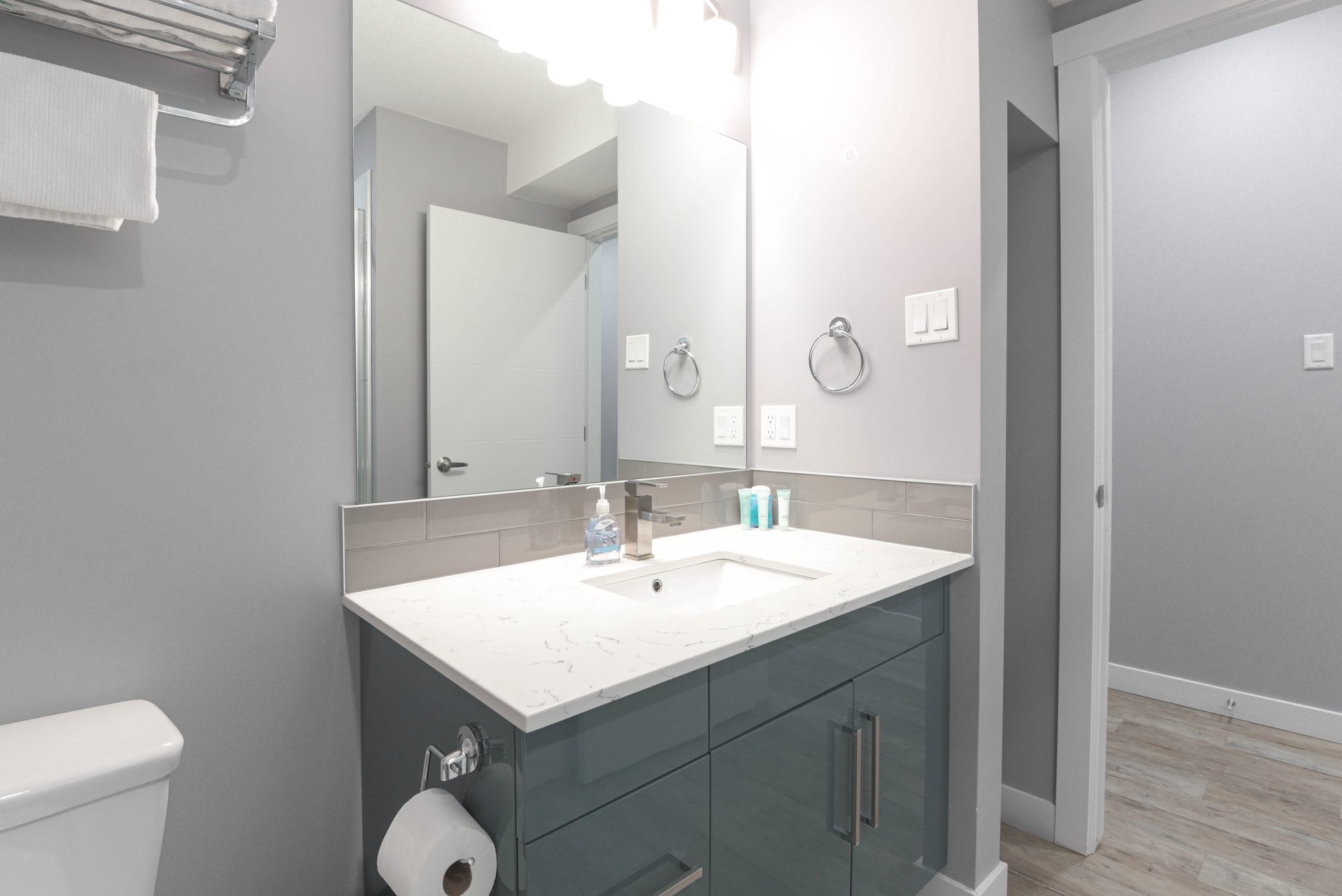 Tiled walk-in shower with glass door beside the bathroom vanity