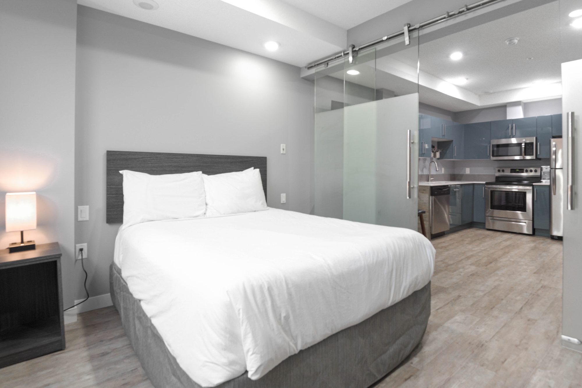 Bedroom with upholstered headboard, bedside lamps, and large window