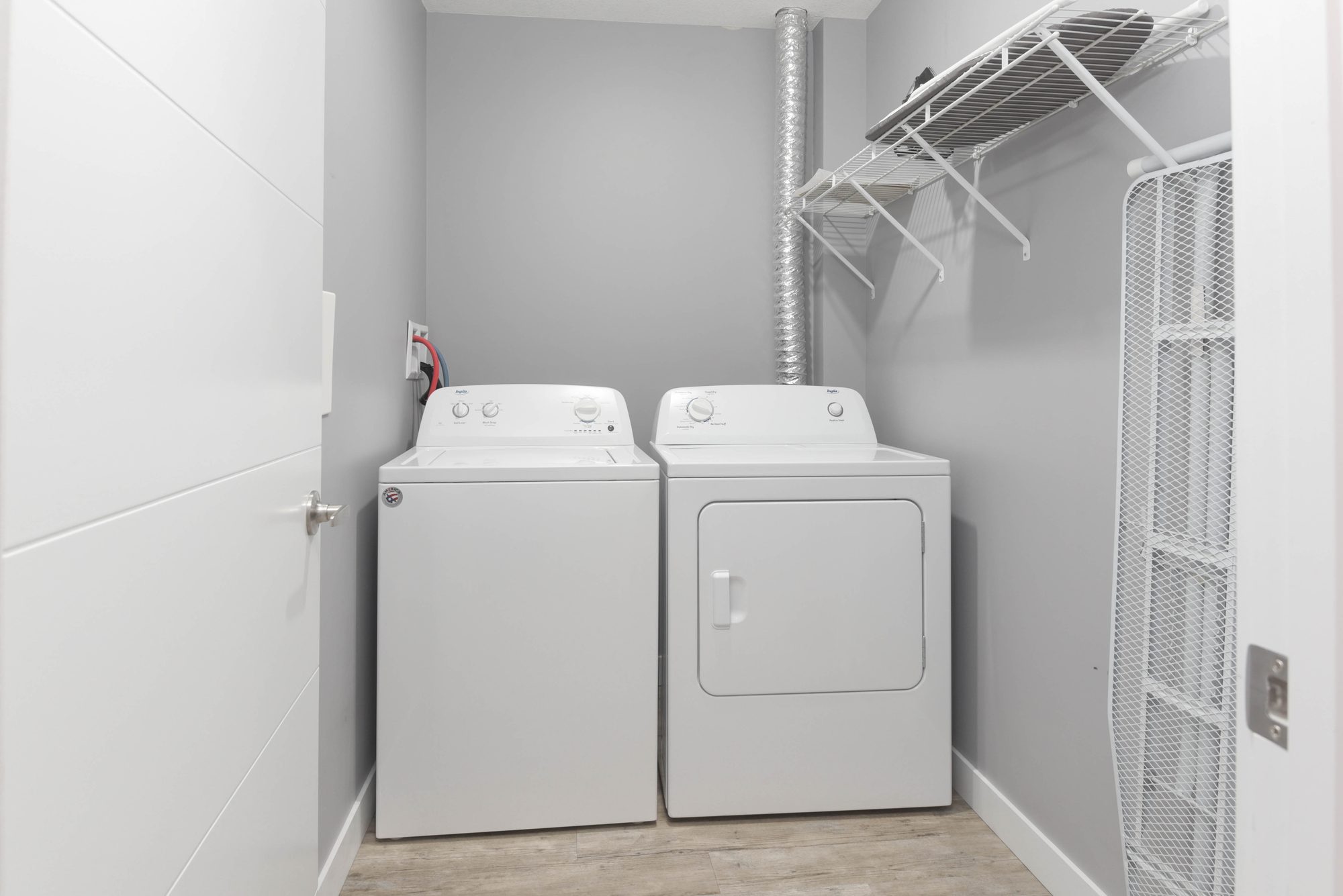 In-suite washer and dryer with wire shelving in a one bedroom suite