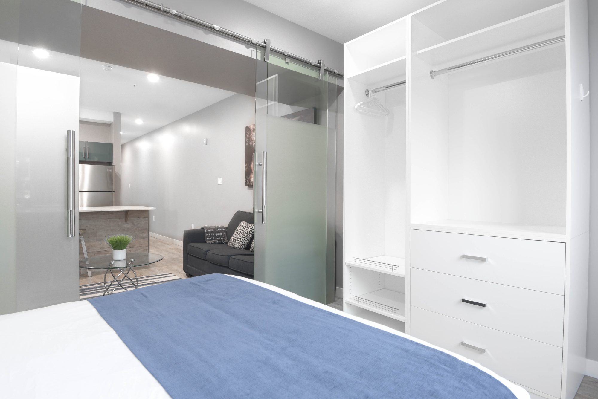 Bedroom with blue bedding, sliding glass door, and built-in wardrobe