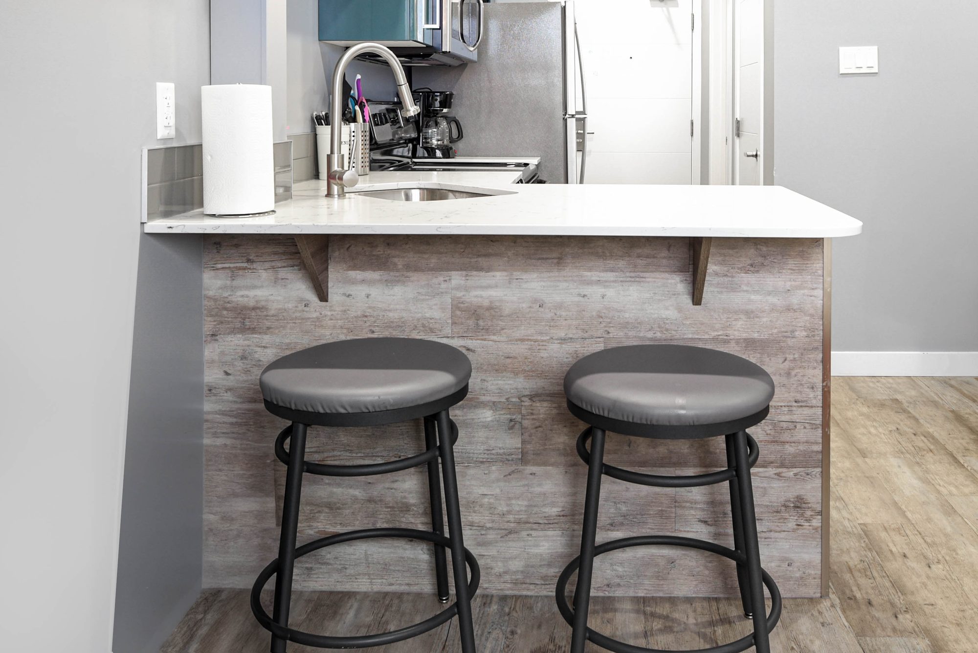 Studio breakfast bar with two stools beside the kitchen sink