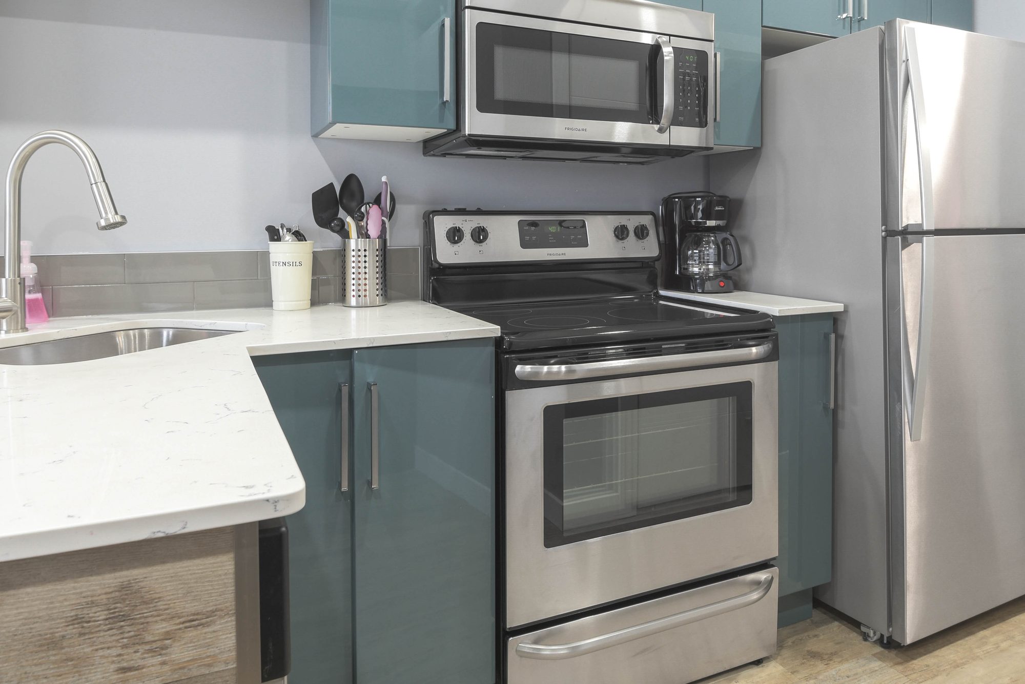 Studio kitchen with stainless steel range, microwave, and refrigerator