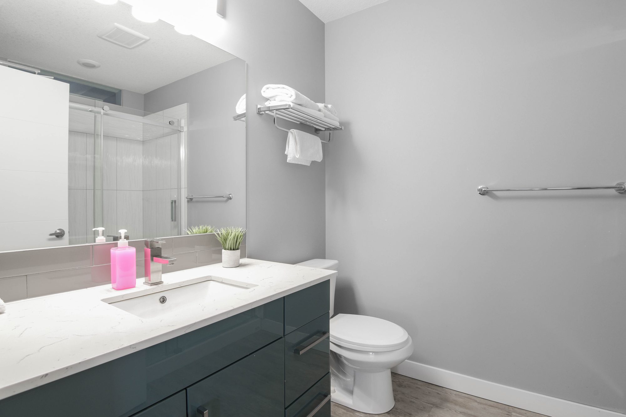 Studio bathroom vanity with quartz countertop and large mirror