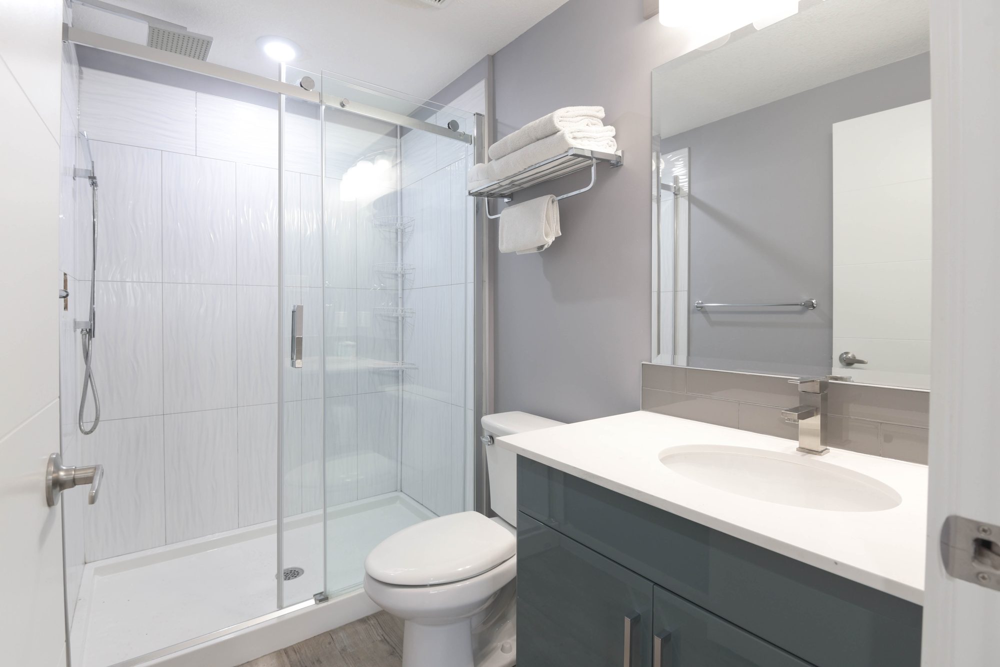 Second bathroom with glass shower, vanity, and towel rail