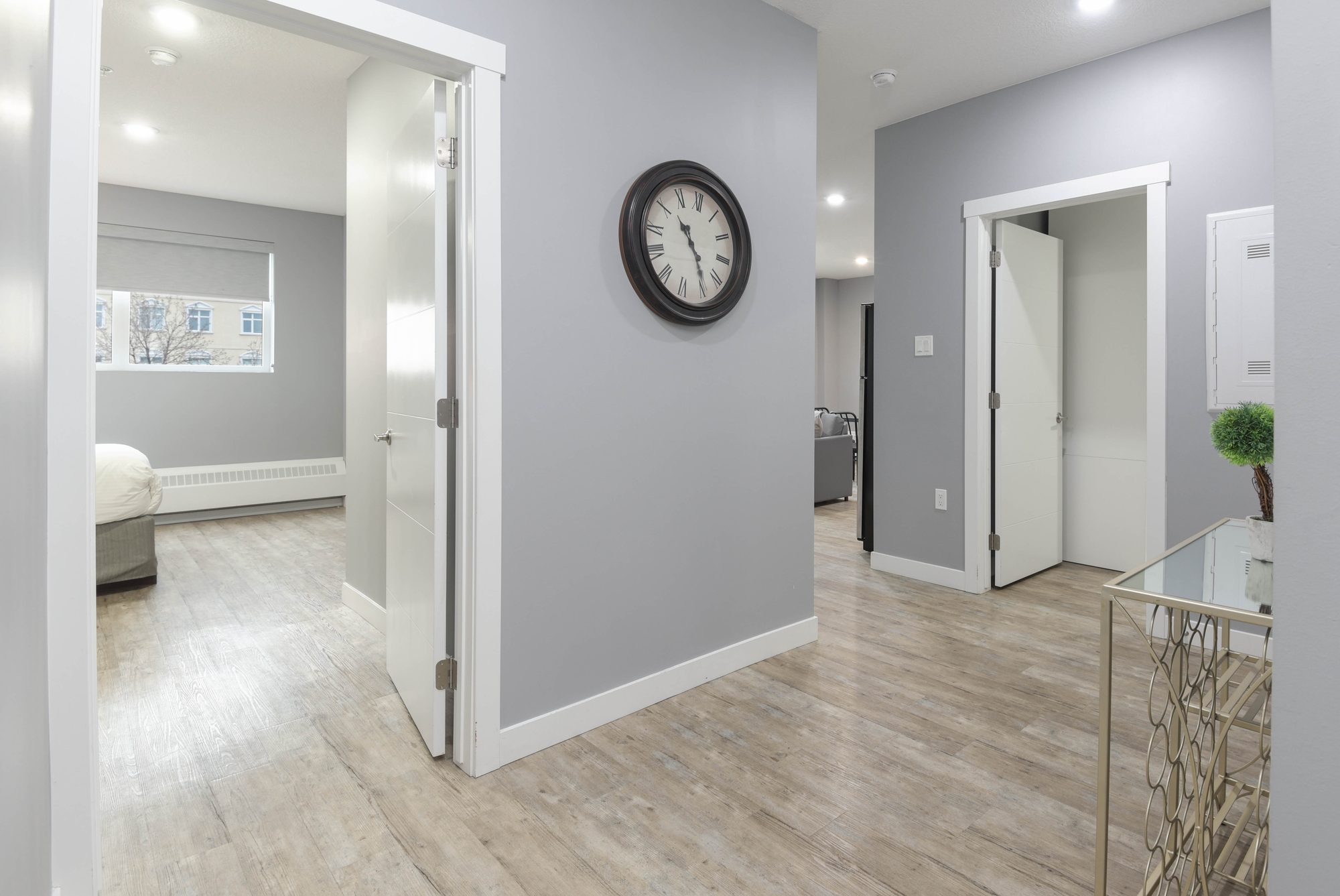 Hallway between the two bedrooms with wall clock and console table