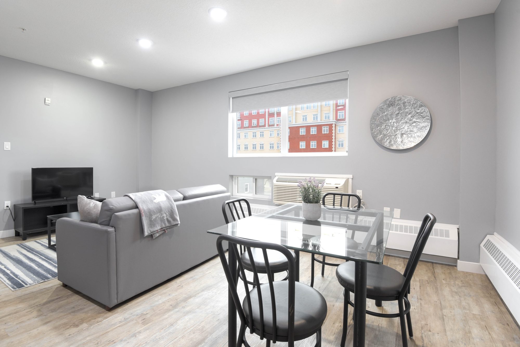 Open living and dining area with sofa, dining set, and TV console